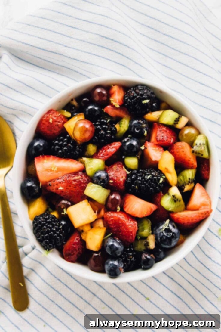 A vibrant rainbow fruit salad, featuring a medley of colorful fresh fruits.