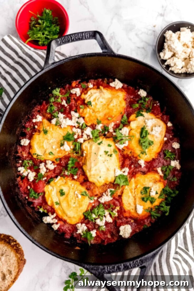 A hearty skillet of vegan shakshuka, with plant-based eggs nestled in a rich tomato sauce.