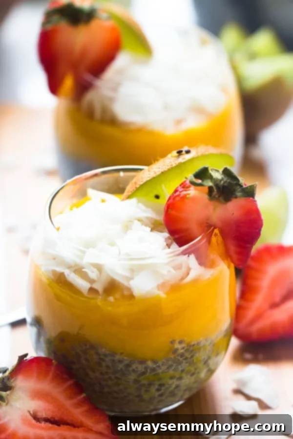 Two glasses full of chia seed pudding, garnished with kiwi and strawberry. 