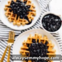 Overhead shot of lemon poppyseed waffles covered with blueberry sauce.