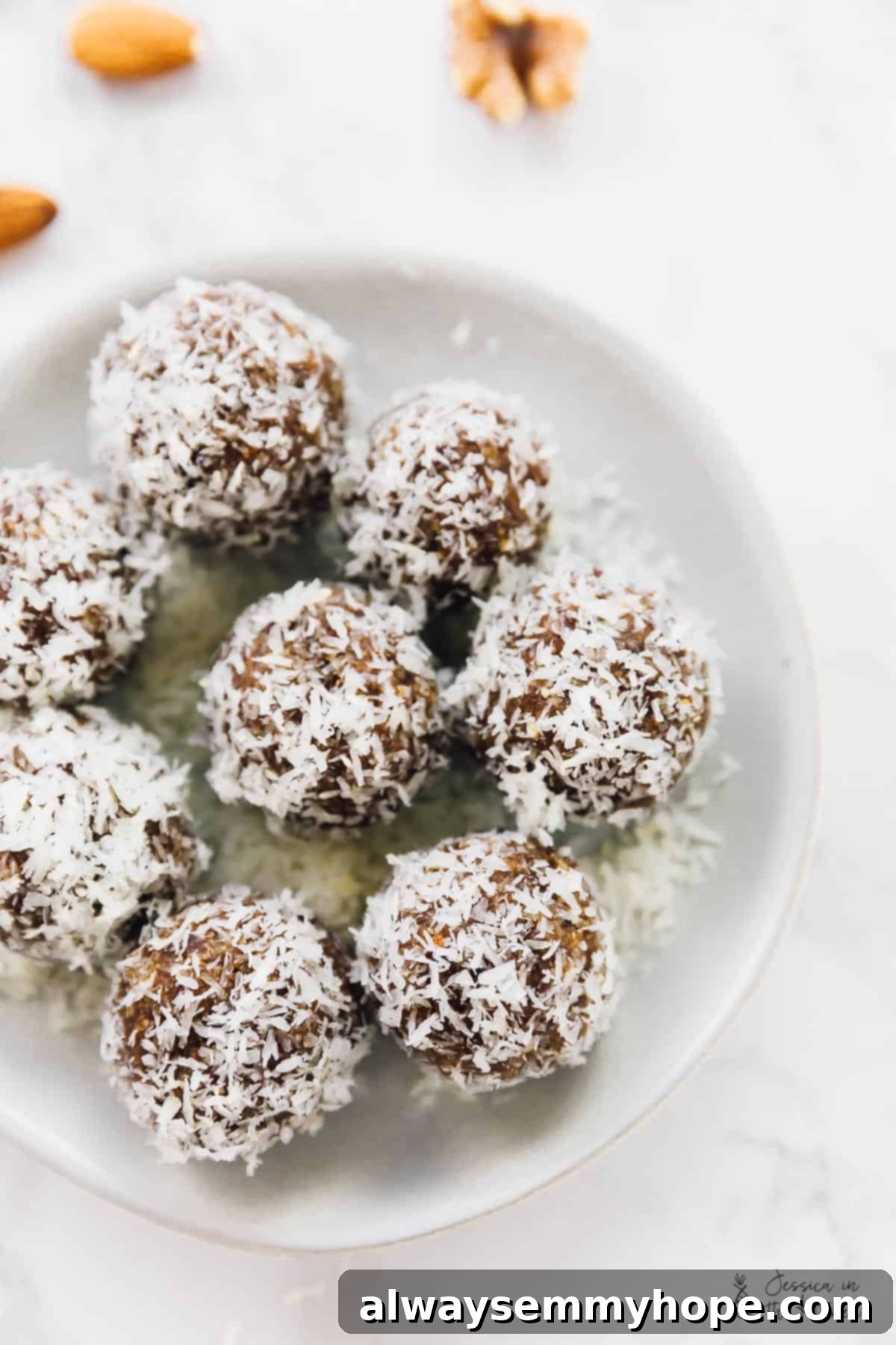 Quick and Zesty Vegan Coconut Lemon Energy Bites 3 Top down view of coconut lemon energy bites nestled in a clean white bowl, highlighting their round shape and snowy coconut coating.