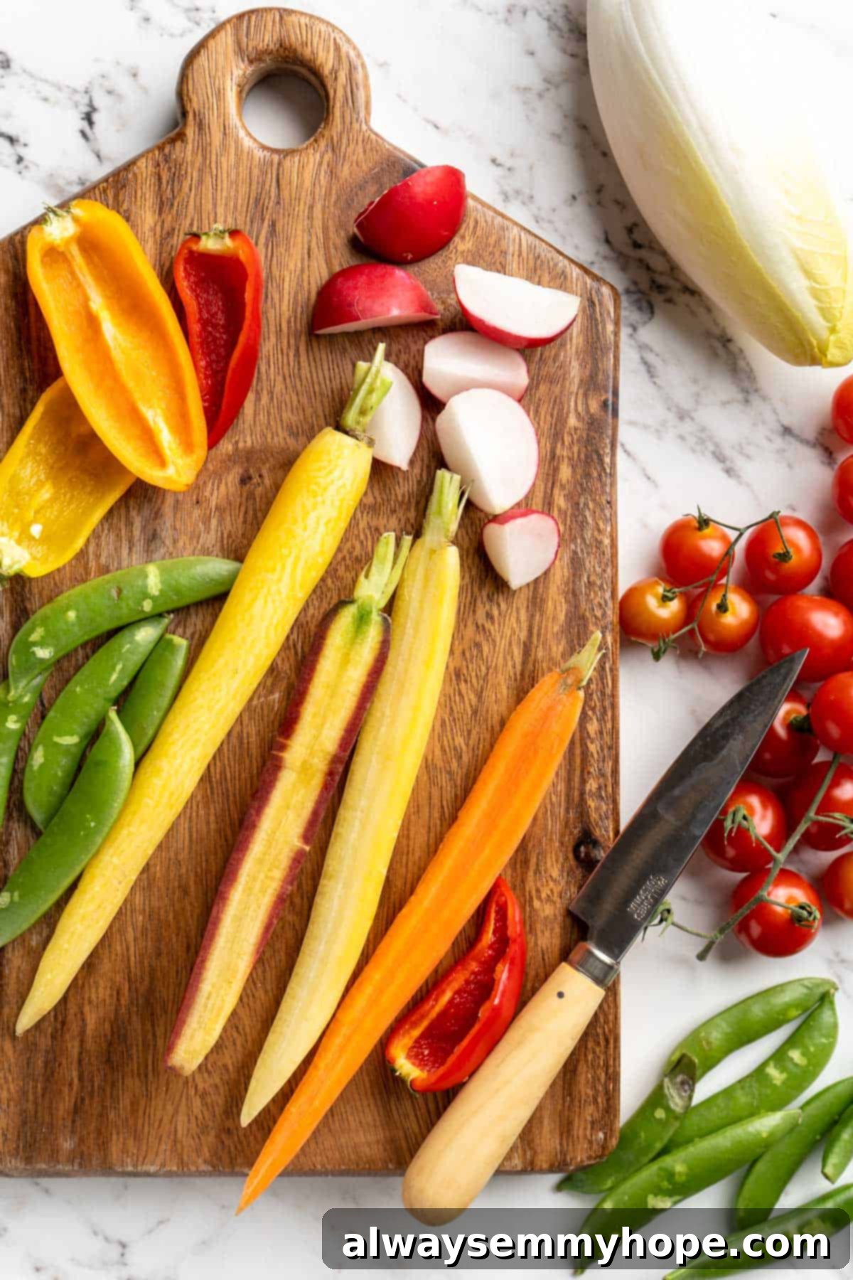 This simple tutorial will show you how to make a perfect vegetable crudité platter that's sure to impress your guests. So easy! Overhead view of vegetables on wood cutting board with paring knife