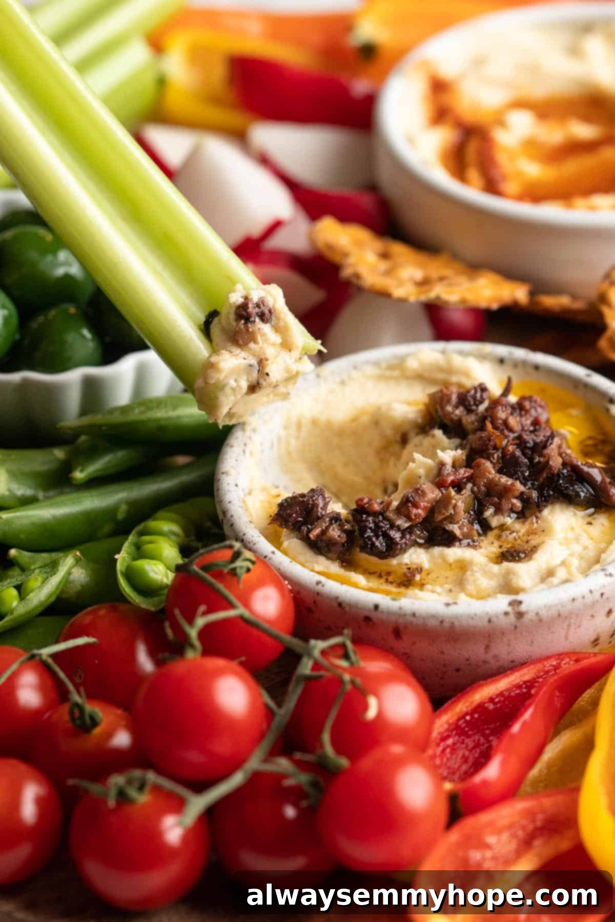 This simple tutorial will show you how to make a perfect vegetable crudité platter that's sure to impress your guests. So easy! Dipping celery into hummus topped with olive tapenade