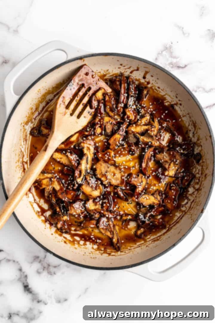 Overhead view of shiitake mushrooms being cooked in enamel cast-iron pan