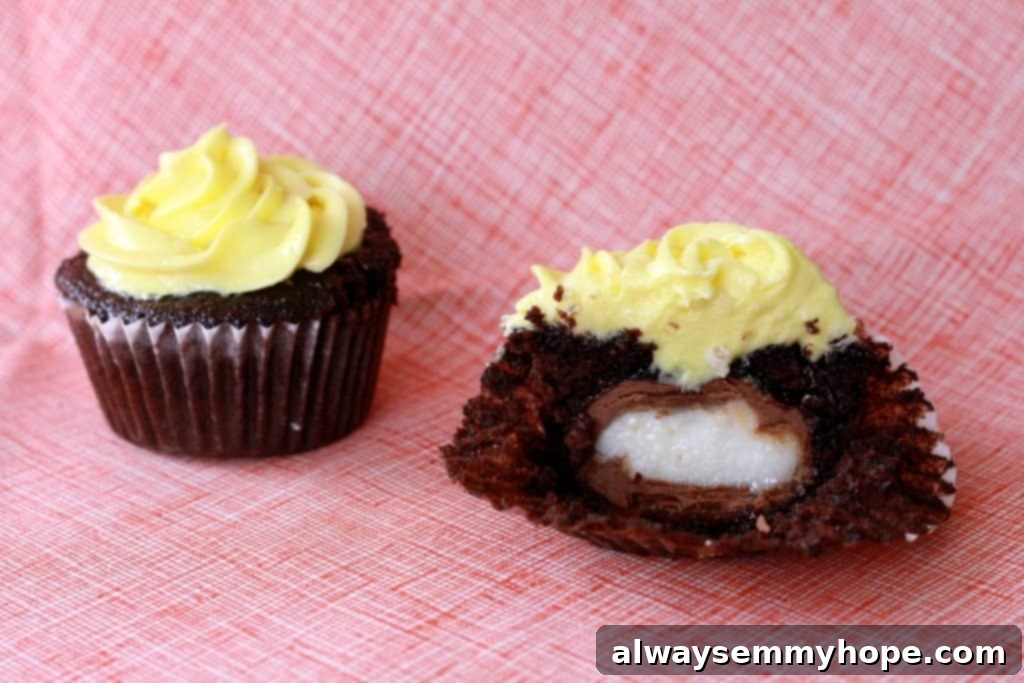Two delightful chocolate Cadbury Egg cupcakes, one expertly cut in half to reveal the gooey chocolate egg surprise inside. Perfect for Easter celebrations.
