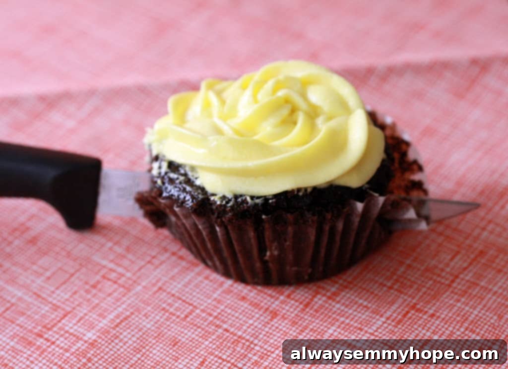 A sharp knife slicing through a chocolate cupcake, revealing the soft, gooey Cadbury egg hidden within its center. A delightful surprise!