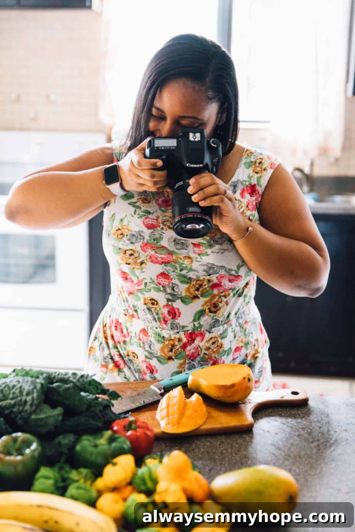 Behind the Plates: A Day with Full-Time Food Blogger Jessica 6 Jessica taking a picture of a mango in a kitchen.