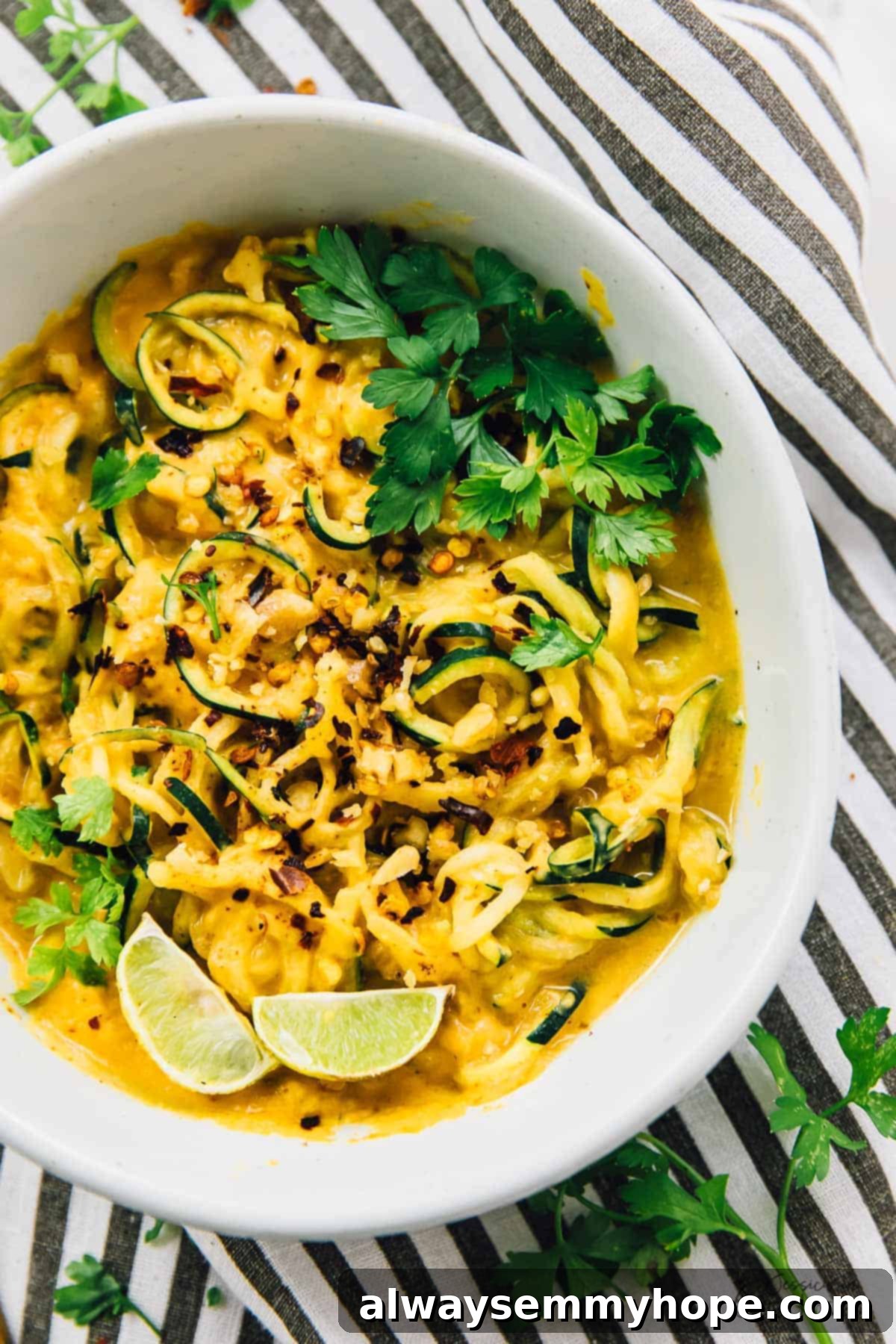 Curried Satay Veggie Power Bowls 5 Top-down view of a colorful curried satay veggie bowl, presented on a striped cloth, ready to be enjoyed.