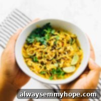 Curried Satay Veggie Power Bowls 7 Hands holding a curried satay veggie bowl.