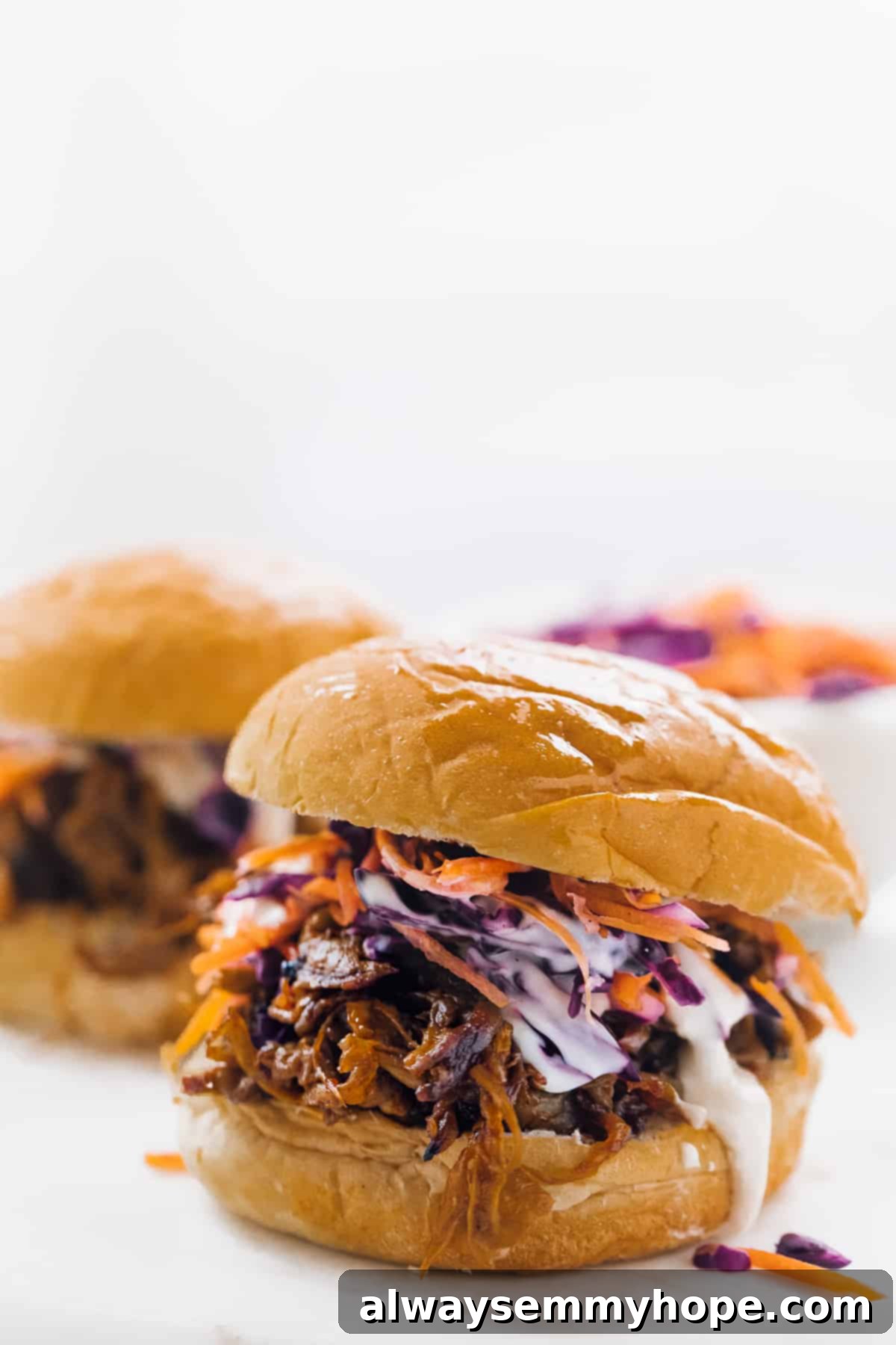 Smoky Vegan Pulled Mushroom Sandwiches 2 side view of pulled mushroom sandwiches on buns with cole slaw