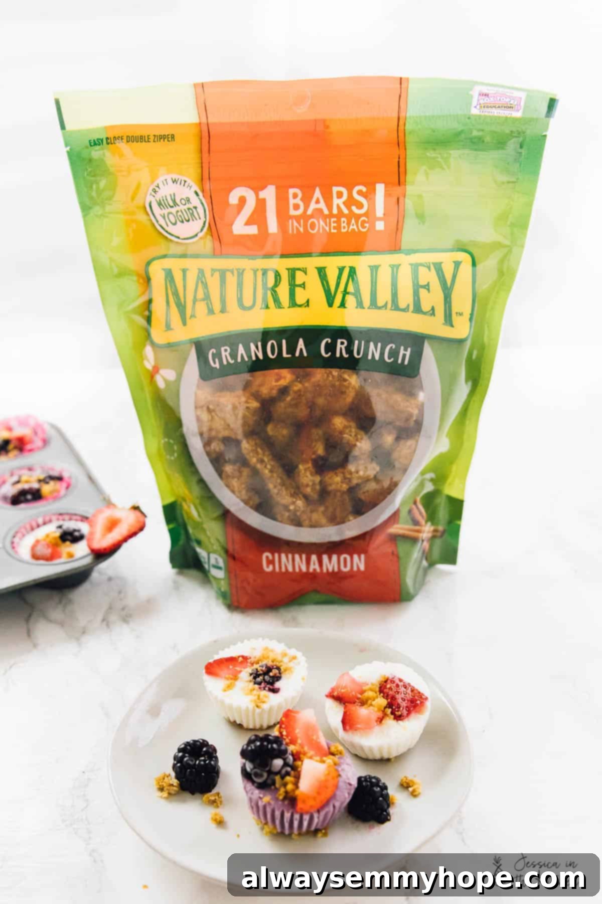 Easy 3-Ingredient Frozen Yogurt Granola Bites 6 Frozen yogurt granola cups on a plate with a pack of granola crunch behind it.