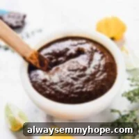 Easy Homemade Jamaican Jerk Sauce 8 Jamaica jerk sauce in a white bowl with wooden spoon sticking out.