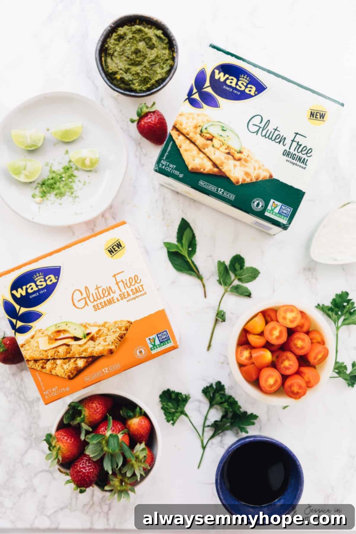 3 Quick and Easy Summer Appetizers With Video 3 Overhead view of various fresh ingredients laid out, including crispbread crackers, cherry tomatoes, strawberries, pesto, and balsamic glaze, ready for appetizer preparation.