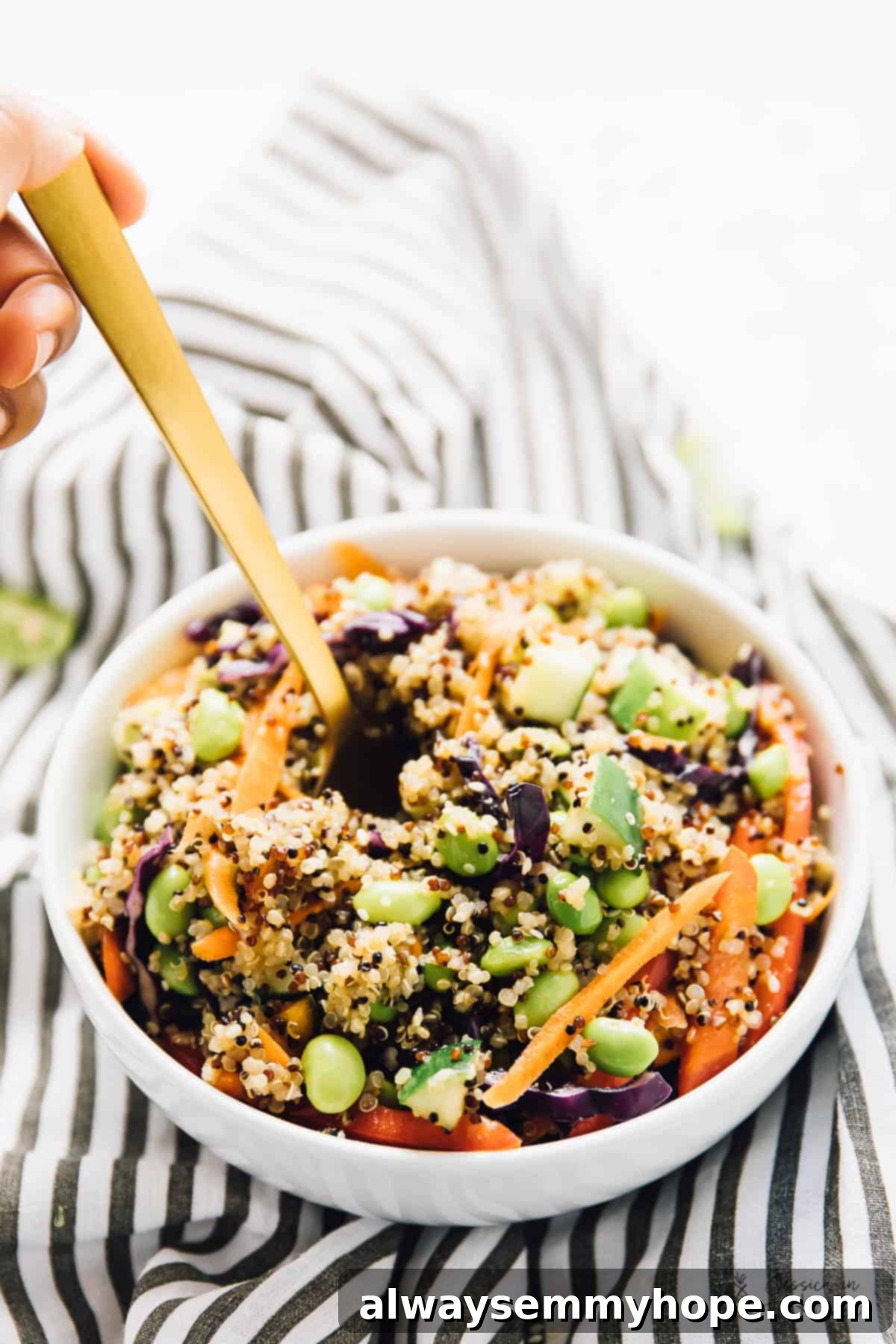 Speedy Sesame Ginger Quinoa Salad 8 Gold spoon digging into bowl of Asian quinoa salad, highlighting the delicious texture