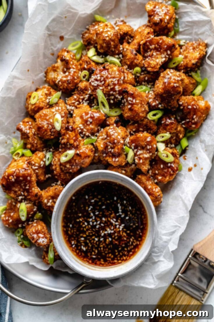 10 Irresistible Vegan BBQ Recipes for Grilling Season 7 Sticky Sesame Cauliflower Wings, beautifully coated in a glossy maple-sesame sauce and garnished with sesame seeds, presented as a delicious vegan snack.