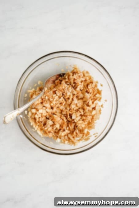 Seasoned unsweetened coconut flakes evenly coated in liquid smoke and other spices.