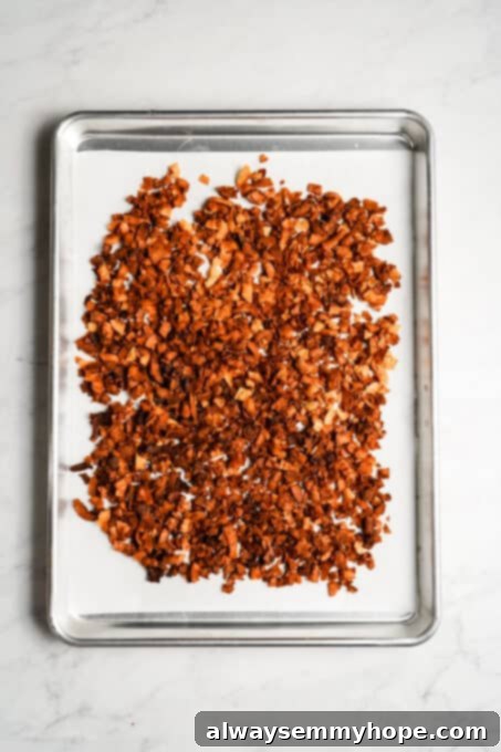 Crispy baked coconut flakes on a cooling tray after being removed from the oven.