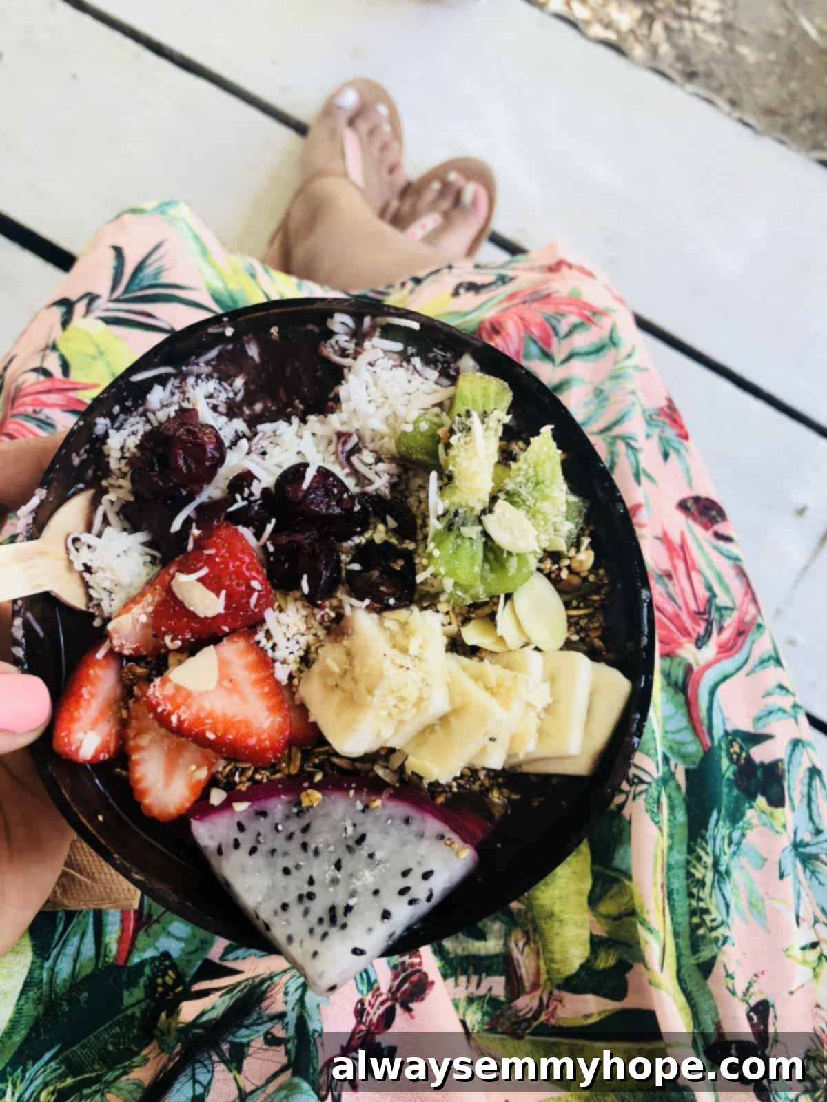 Top down shot of a vibrant breakfast spread featuring chopped strawberries, kiwis, and dragon fruit in a bowl.