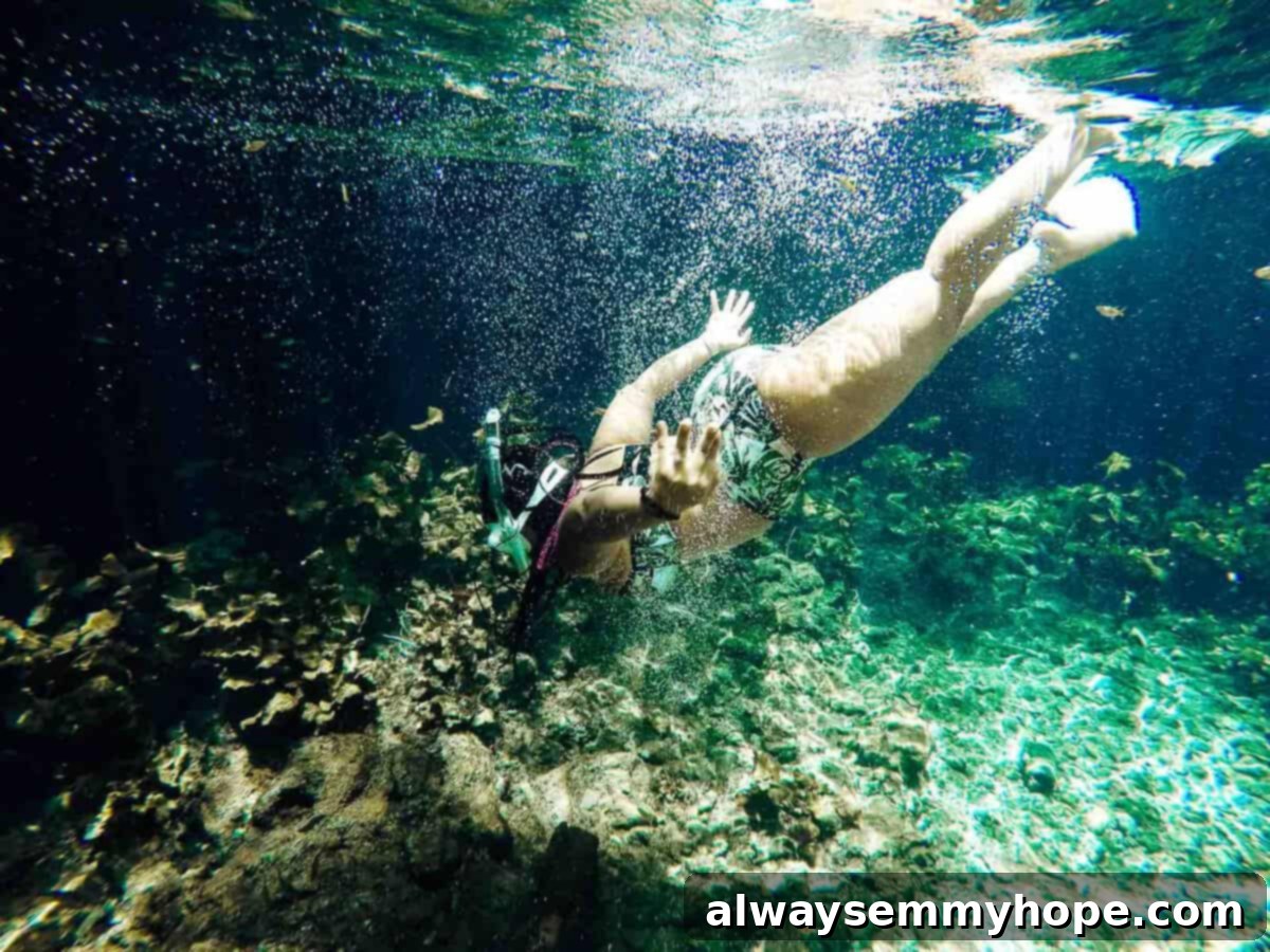Jessica swimming gracefully underwater with a snorkel, surrounded by vibrant marine life.