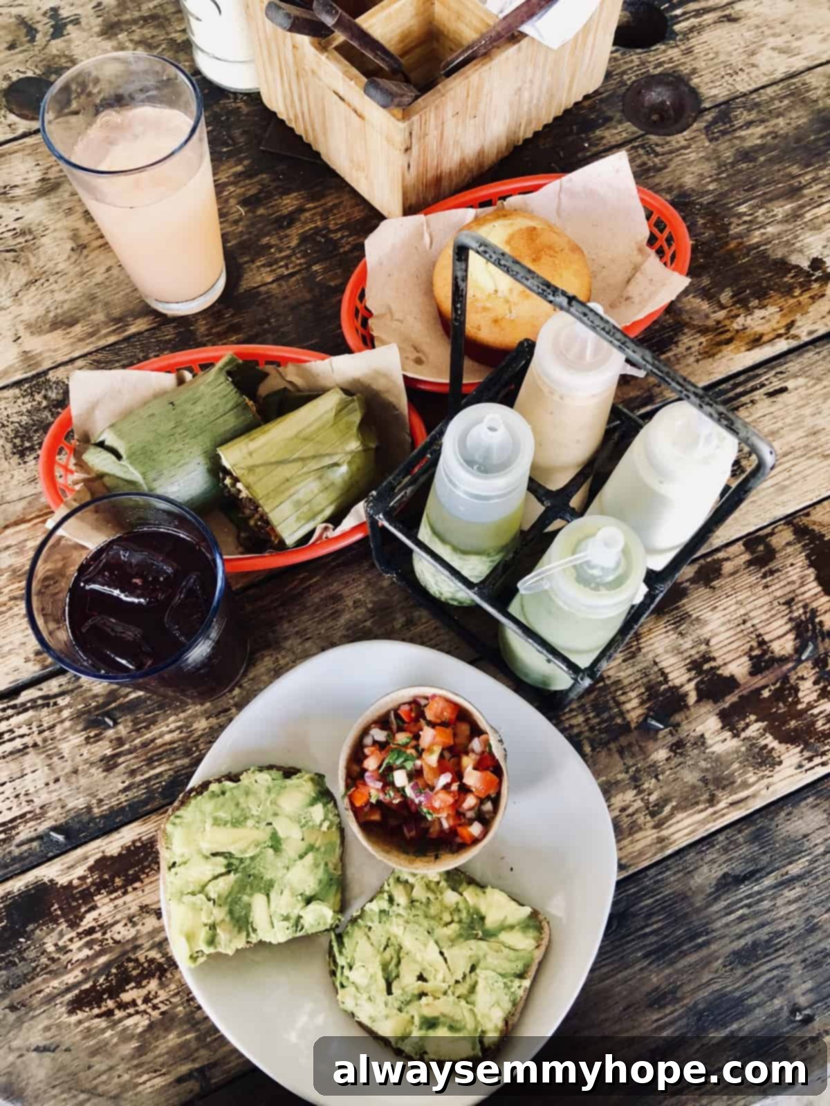 Overhead view of an abundant spread of plates and woven baskets filled with delicious food, arranged on a rustic wooden table.