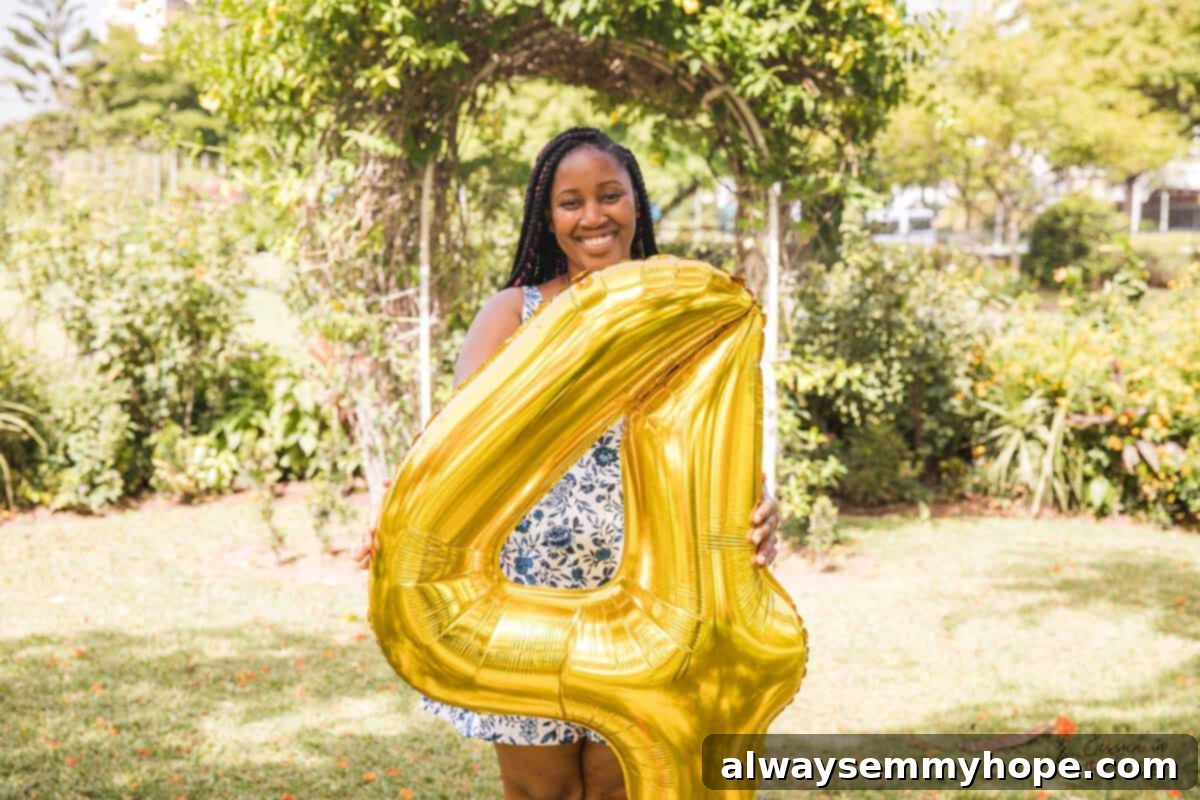 Jessica laughing while holding a large gold number four balloon in a lush green park, celebrating her blog's anniversary.