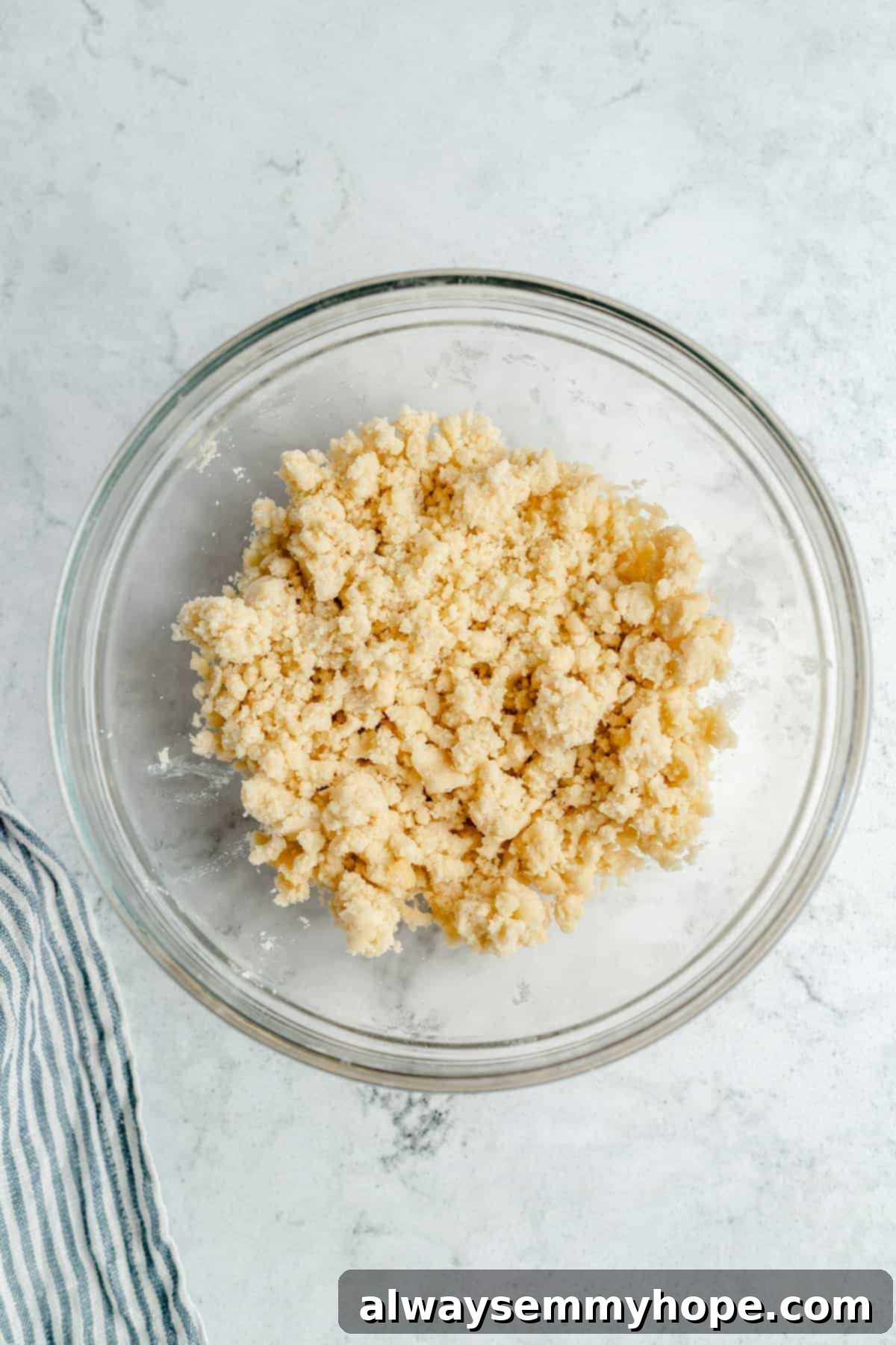 Mixed shortbread crust ingredients in a bowl, showing a crumbly texture.