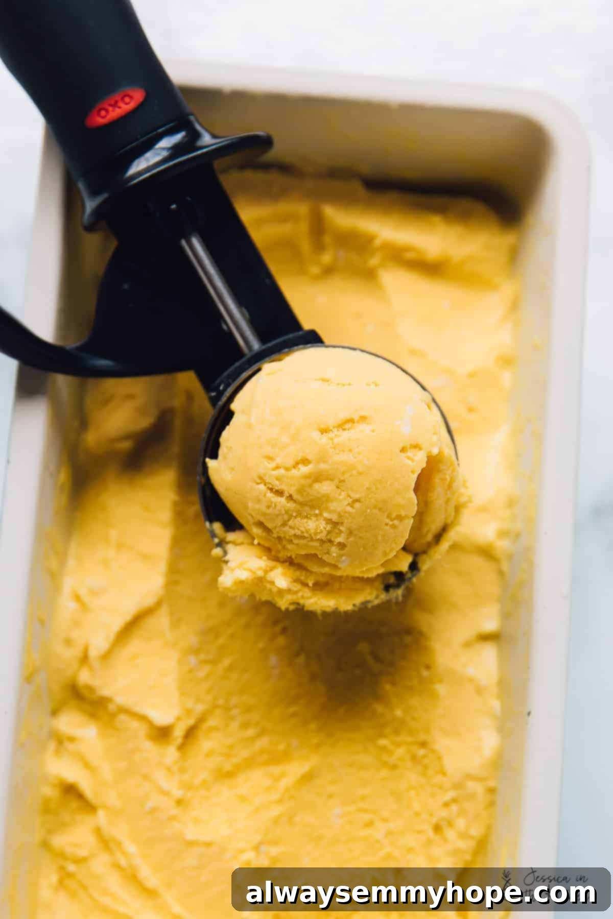 Ice cream scooper scooping mango ice cream