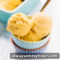 Three scoops of mango ice cream in a bowl.