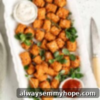 Overhead view of sweet potato tots on white platter with dipping sauces in bowls