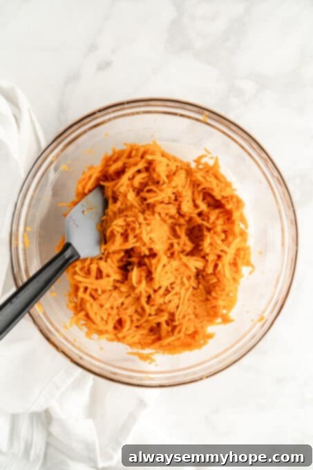 Glass bowl filled with the thoroughly mixed sweet potato tater tot mixture