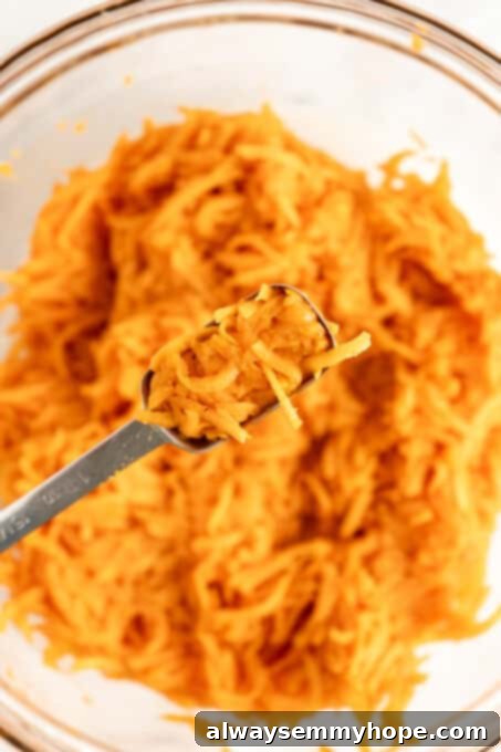 A measuring spoon filled with the sweet potato tot mixture, ready to be formed