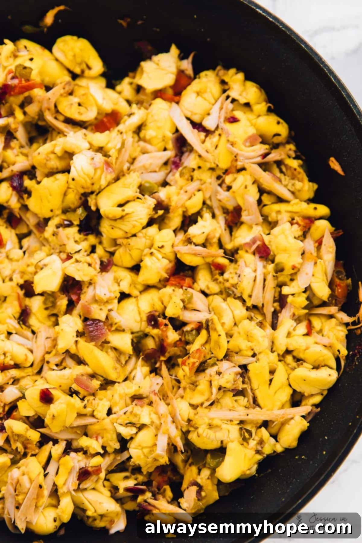 Top down view of vegan ackee and saltfish, in a black skillet. 