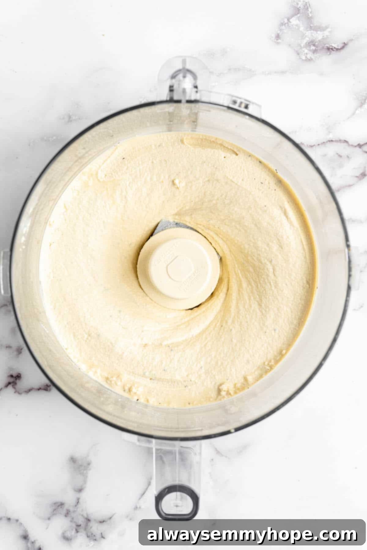 Creamy tofu 'egg' mixture for vegan quiche in a food processor bowl, ready for mixing.