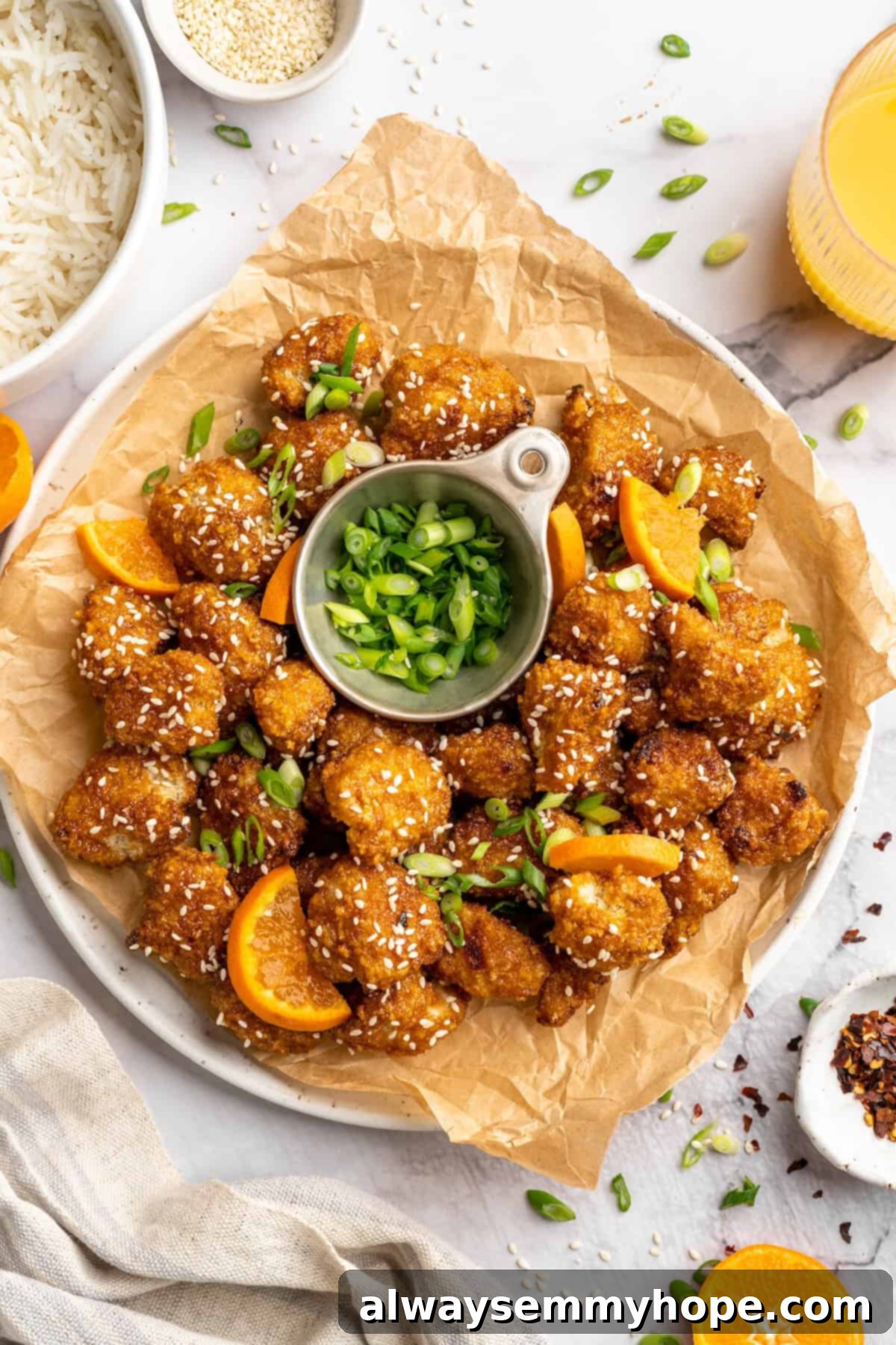 Serving Platter of Baked Orange Cauliflower Overhead view of crispy orange cauliflower on platter with bowl of scallions