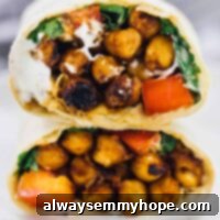 Smoky BBQ Chickpea Wraps with Creamy Ranch 6 A bbq chickpea wrap cut on half on a plate.