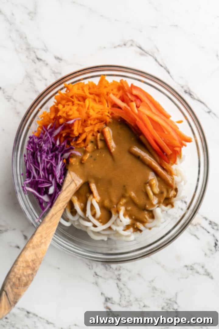 Overhead view of ingredients for Thai peanut noodles in mixing bowl before stirring