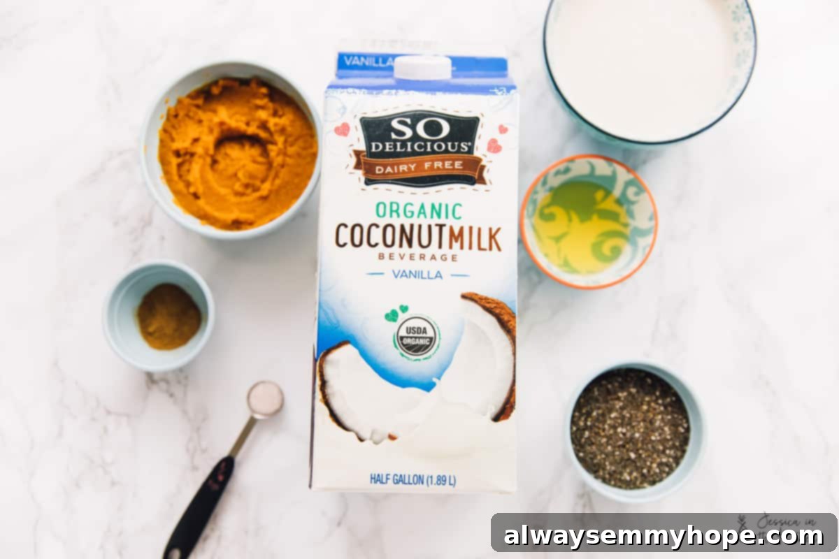 Easy vegan pumpkin chia pudding is rich, creamy, and full of fall flavors like hearty pumpkin, warm spices, and buttery pecans. Overhead view of the ingredients needed for pumpkin chia pudding: a carton and a bowl of of coconut milk beverage, a bowl of pumpkin puree, a bowl of agave, a bowl of chia seeds, a bowl of pumpkin pie spices, and a measuring spoon of salt