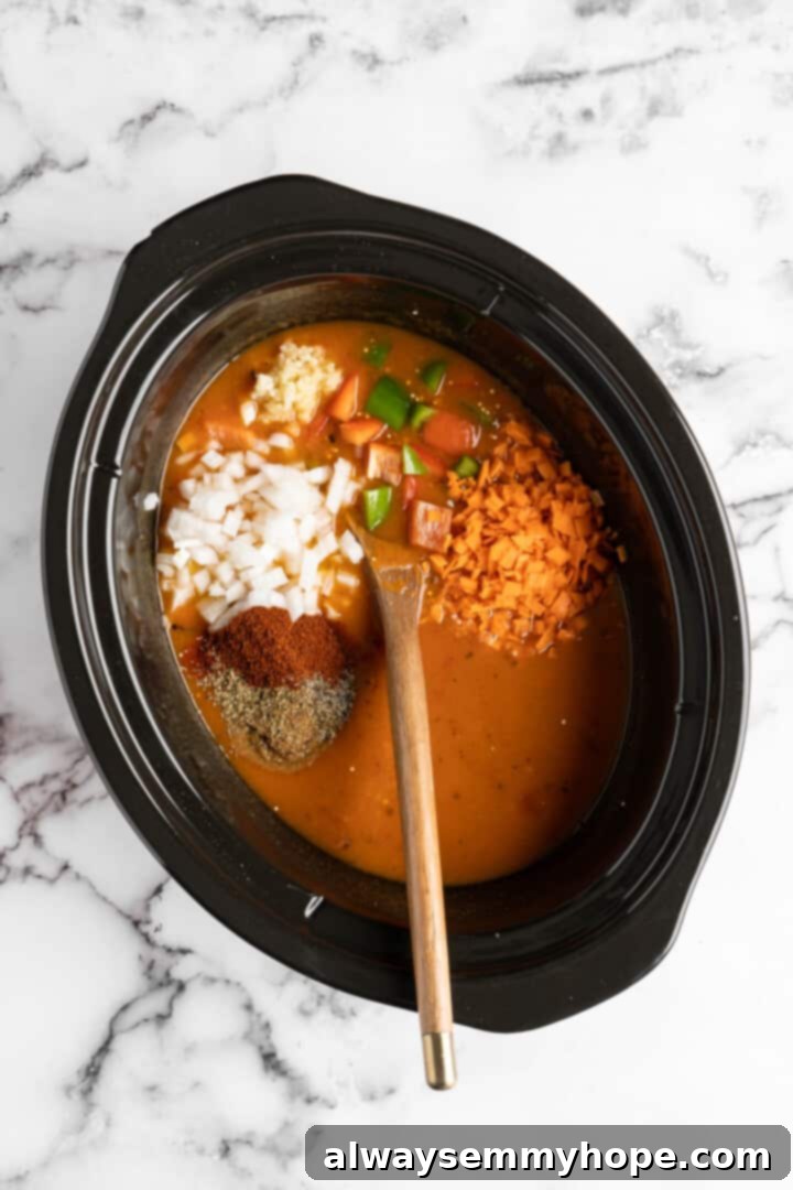 Adding vegetable broth, quinoa, black beans, diced tomatoes, and pumpkin puree into a slow cooker.