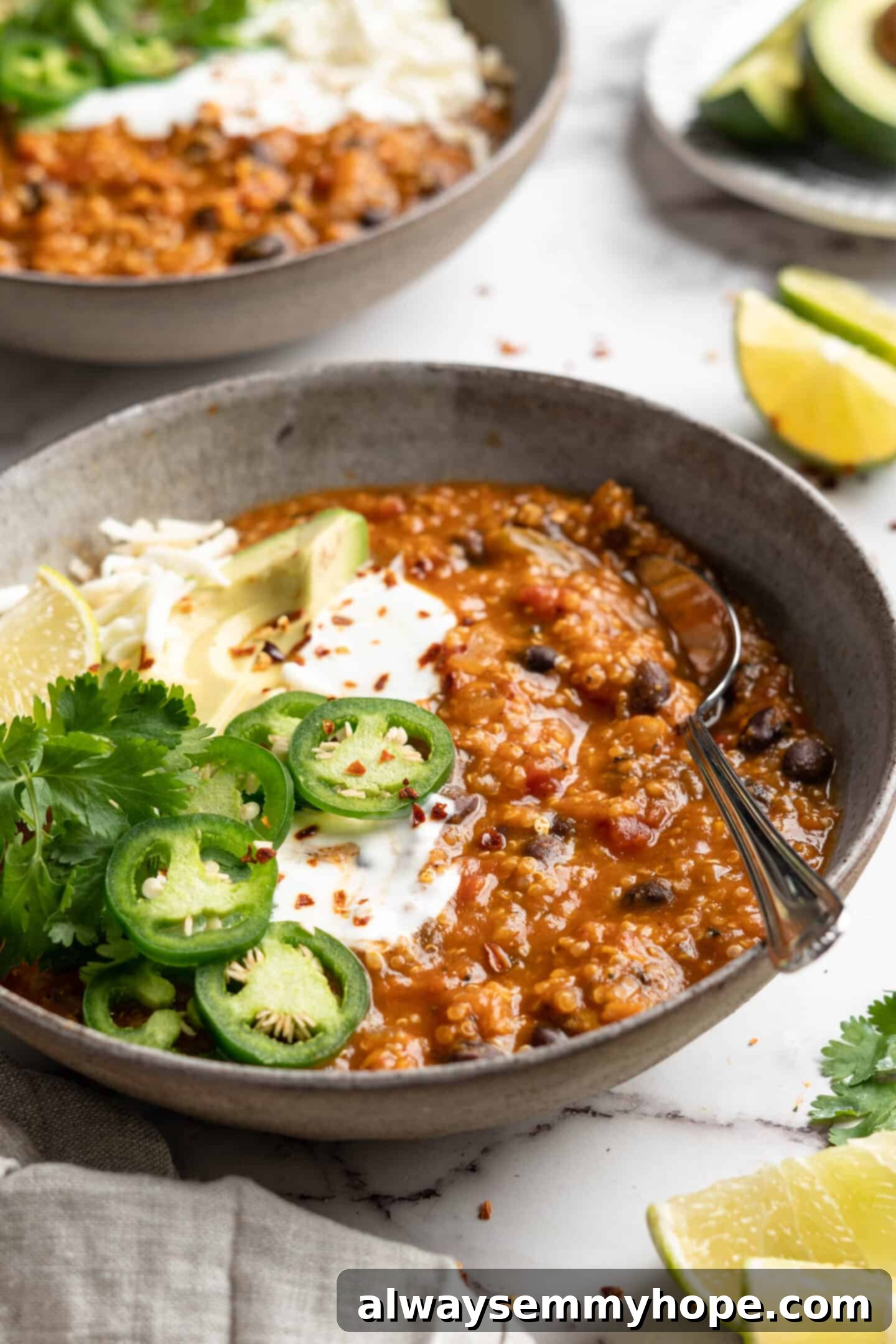 A large, rustic bowl of vegan pumpkin chili with a spoon resting in it, ready to be enjoyed as a warm and hearty meal.