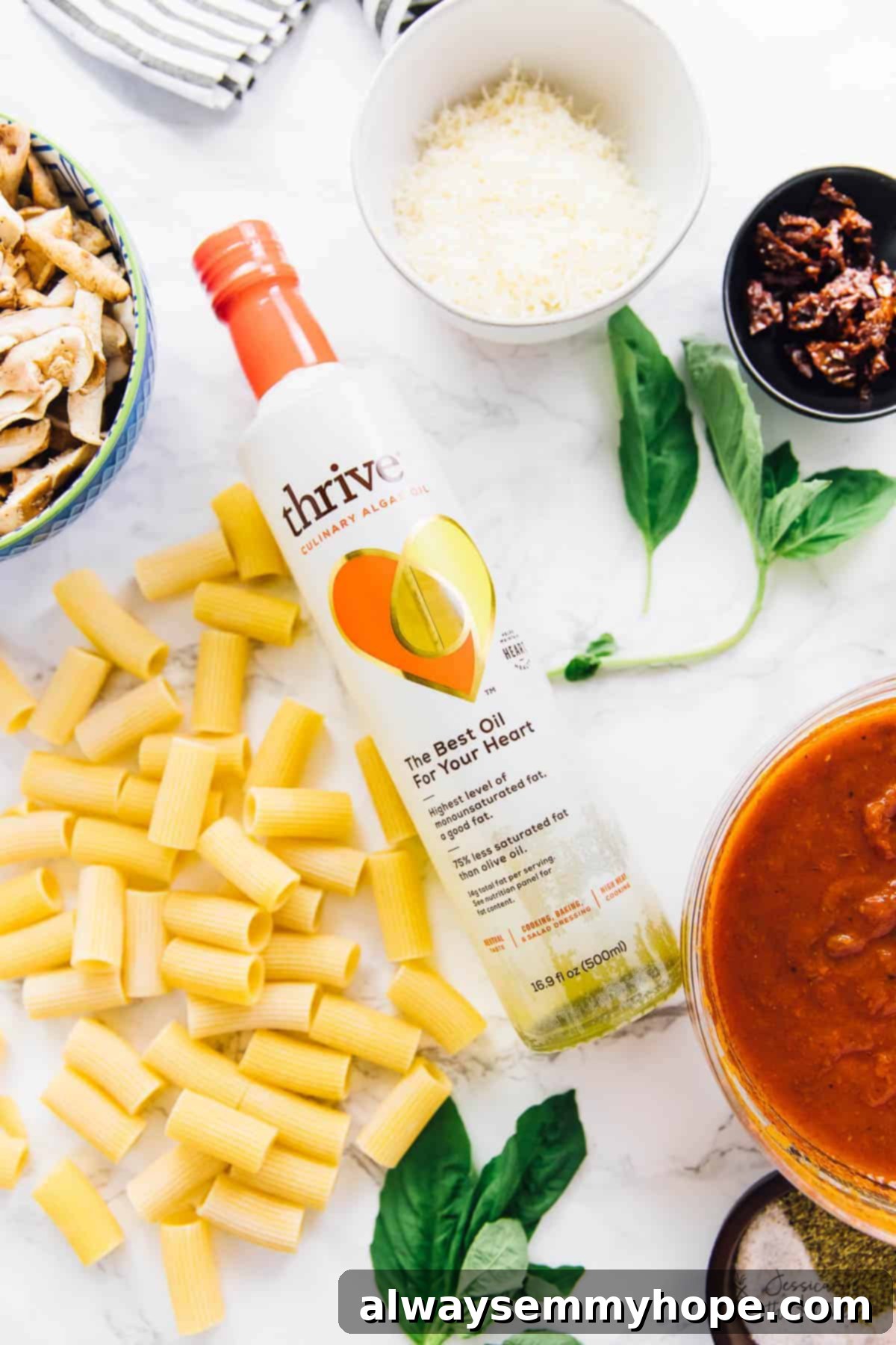 Creamy Vegan Cheese Pasta Bake 3 Overhead view of dried pasta, mushrooms, vegan cheese and tomato sauce, on a table.