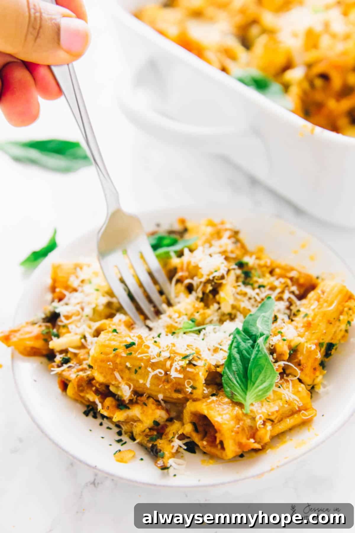 Creamy Vegan Cheese Pasta Bake 4 A fork digging into vegan cheese pasta bake, on a plate.