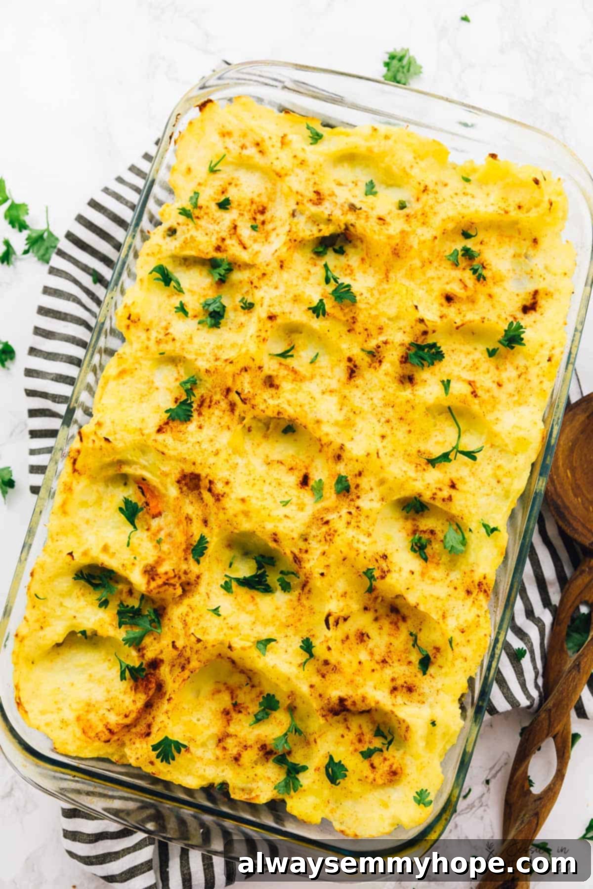 Regal Shepherd's Pie 4 A stunning top-down view of the golden-brown vegan shepherd's pie baking in a clear glass dish, highlighting its comforting layers.