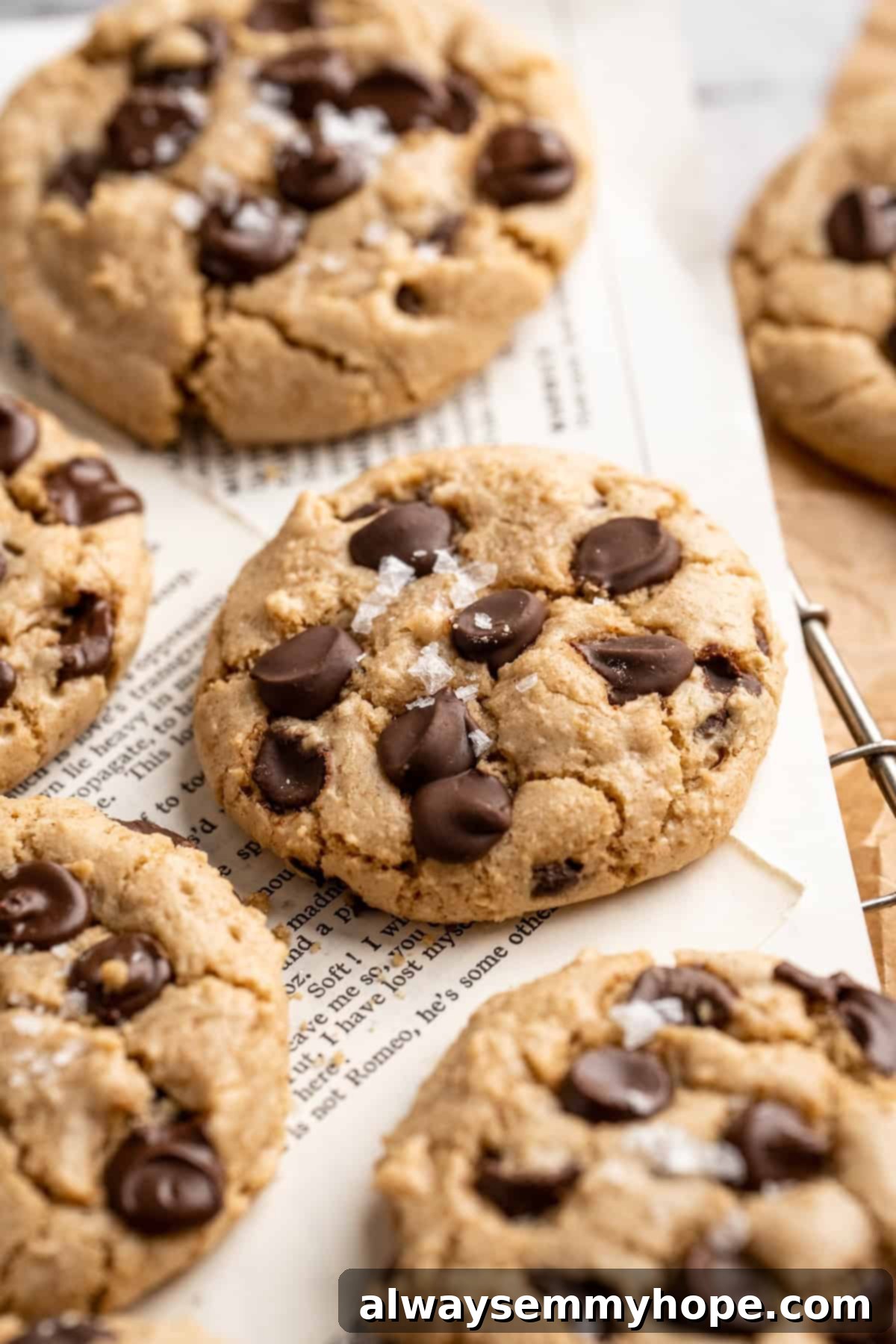 Savor the moment with these delicious Salted Chocolate Chip Tahini Cookies, a perfect blend of nutty, sweet, and salty flavors. A stack of warm tahini chocolate chip cookies with melted chocolate and a sprinkle of flaky sea salt.
