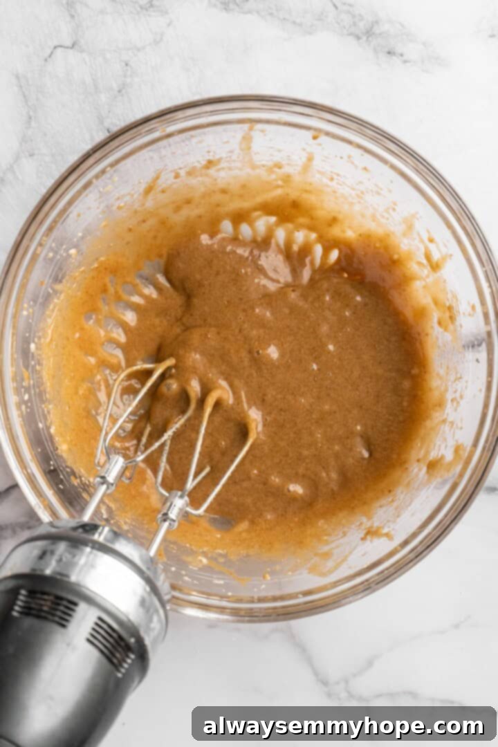 Decadent Chewy Salted Tahini Chocolate Chip Cookies 3 Wet ingredients including brown sugar, tahini, flax egg, vanilla, and coconut oil being whipped together until fluffy.