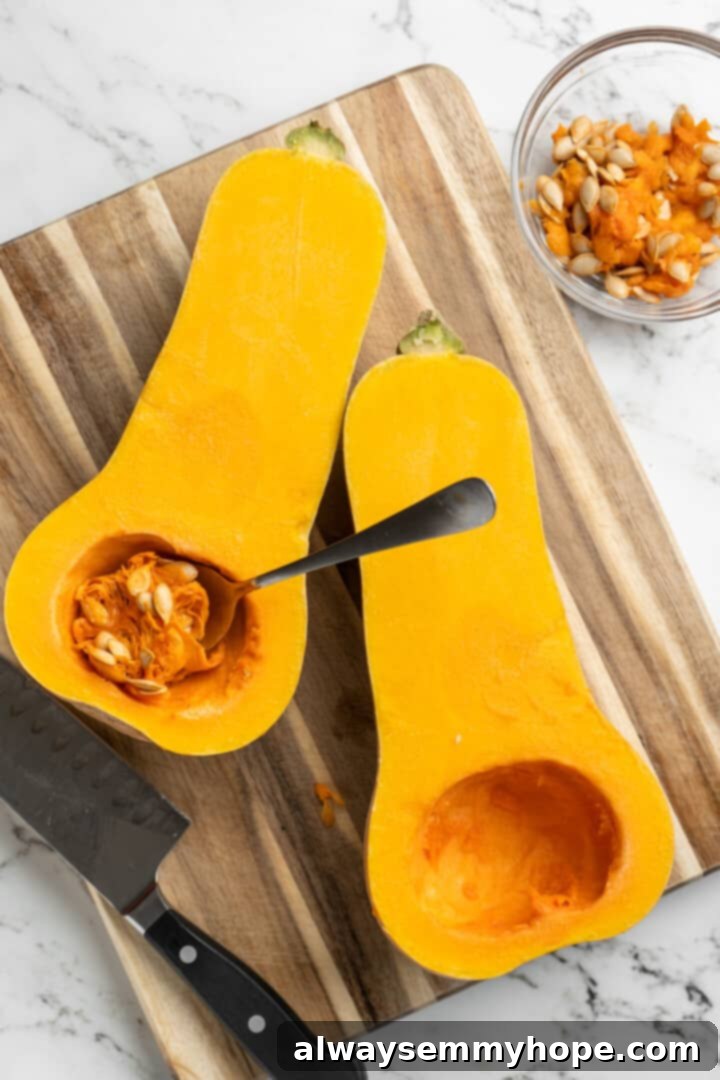 Hasselback butternut squash is a show-stopper, but it’s not all looks! Maple, tender squash, and caramelised pecans make it irresistible! Overhead view of butternut squash halves, one with seeds removed and the other with a spoon in the process of removing seeds