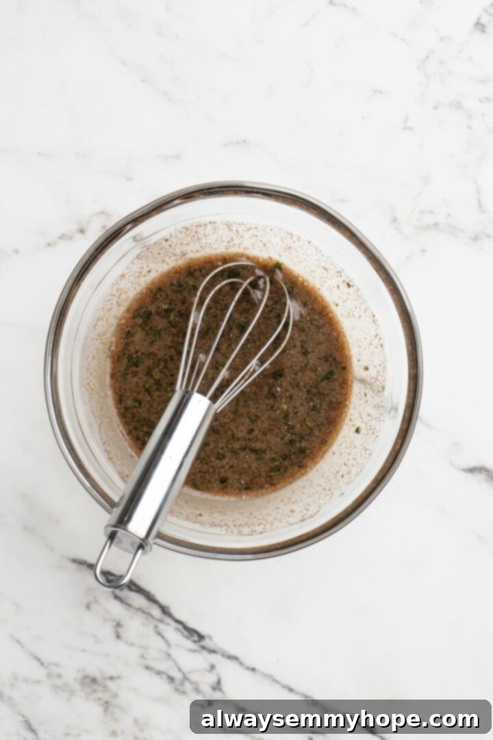 Hasselback butternut squash is a show-stopper, but it’s not all looks! Maple, tender squash, and caramelised pecans make it irresistible! Overhead view of maple pecan drizzle ingredients being whisked together in a small bowl