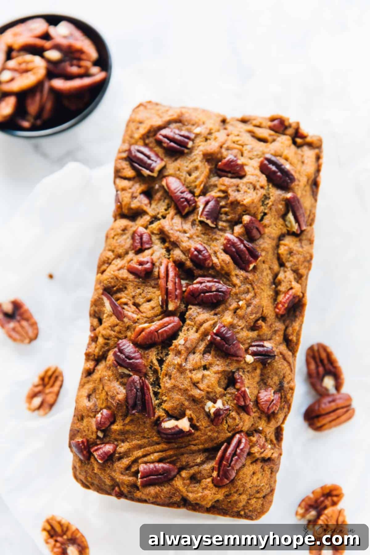 Overhead shot of banana bread, topped with pecans.