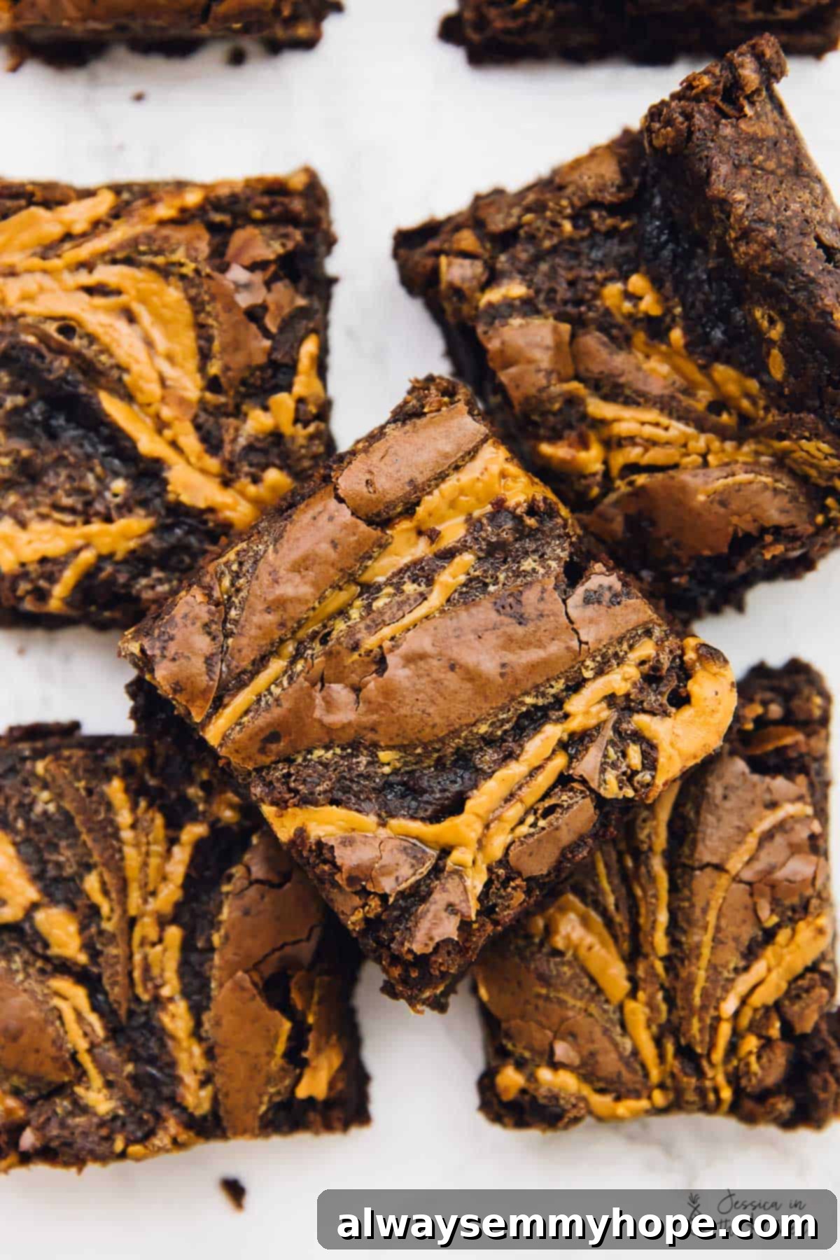 Top down view of vegan chocolate peanut butter swirl brownies on a white table. 