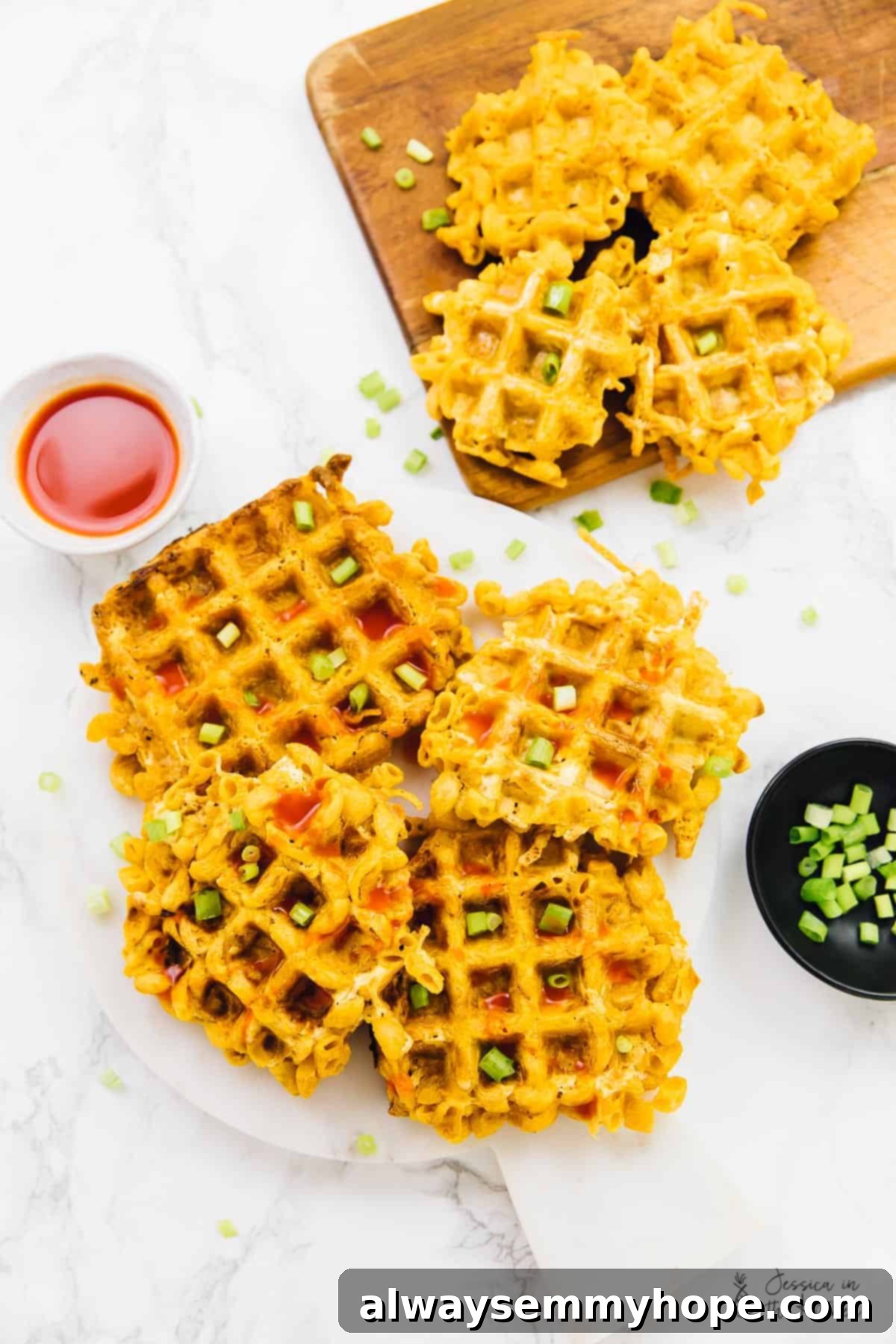 Overhead view of mac and cheese waffles on a plate and a board.