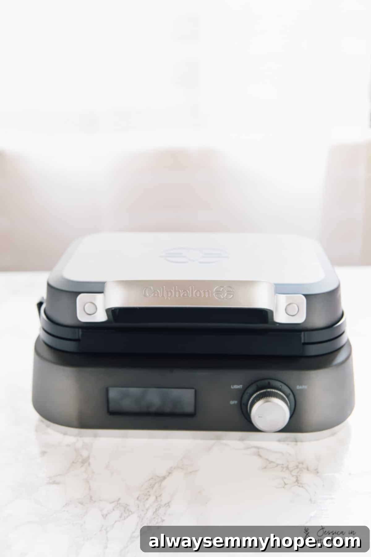 The sleek Calphalon IntelliCrisp Waffle Maker, sitting elegantly on a kitchen surface, ready for another delicious batch of waffles.